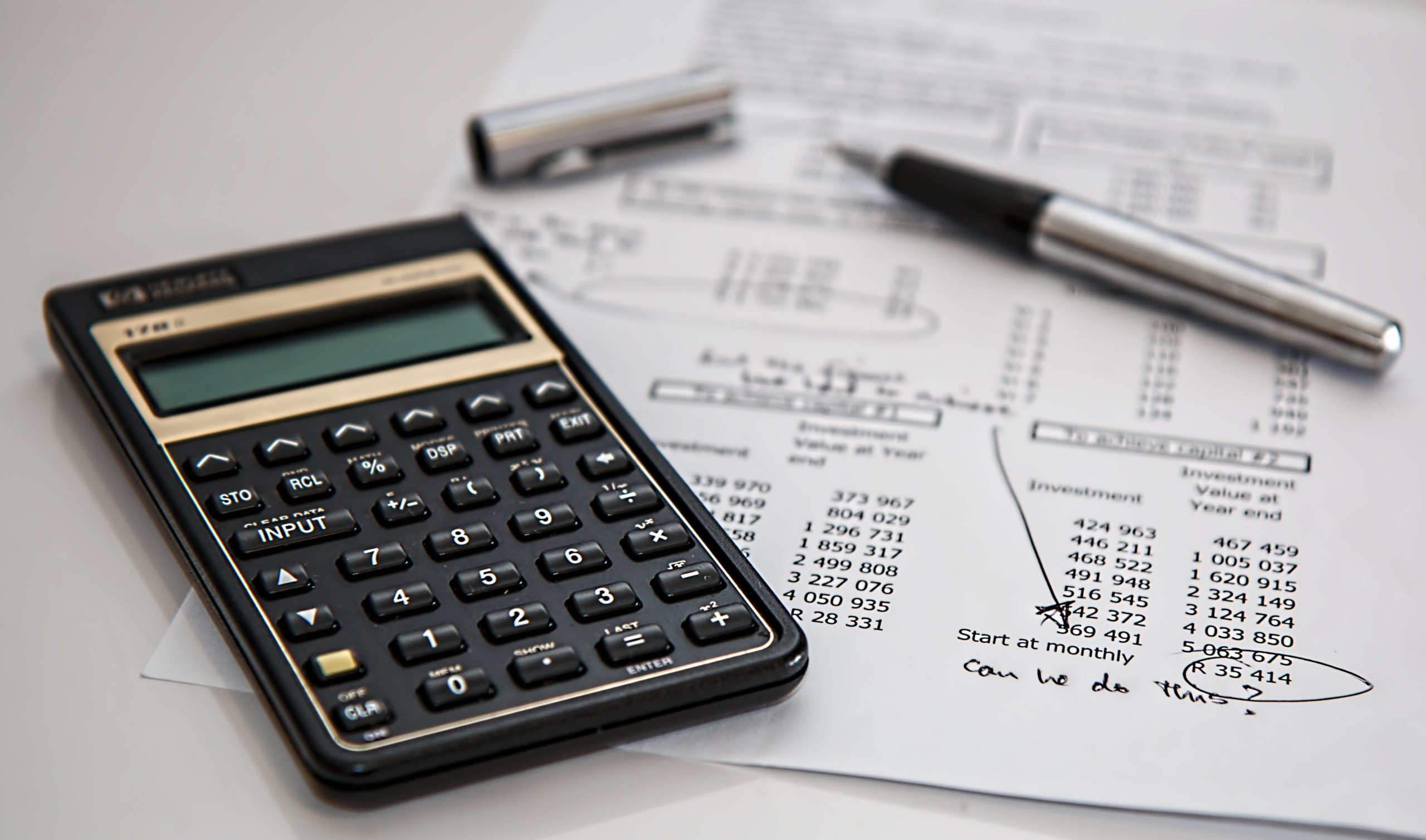 Pen and financial calculator on print out of roofing budget